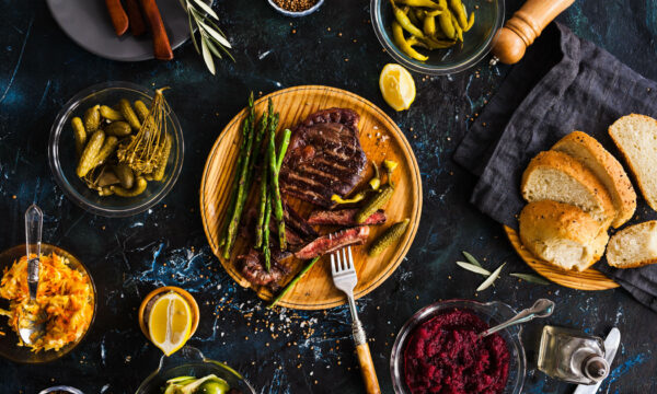 BBQ Beef steak with pickled veggies, cucumber, cabbage, beeroot, Grilled steak with asparagus and pickled peppers on a wooden plate.