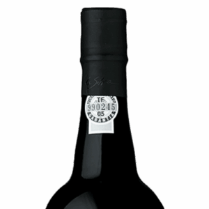 A close-up of a dark wine bottle with a black foil seal and a small white label near the top.