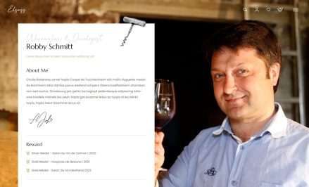 A man holding a glass of wine with a website about wine tasting in the background.
